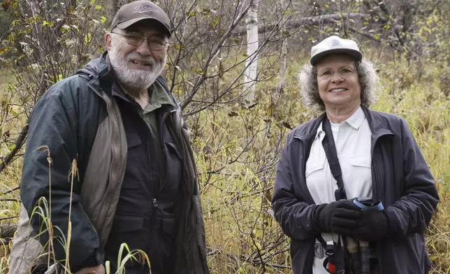 Joe Cantil, left, and Donna Gail Shaw, pose for a photo on Sept. 26, 2024, in Anchorage, Alaska. The two are the co-administrators of a Facebook group that features wildlife videos captured on their trail cameras very near a populated Anchorage neighborhood. (AP Photo/Mark Thiessen