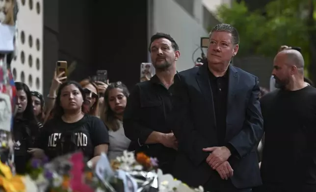 Geoff Payne, right, the father of former One Direction singer Liam Payne, visits a memorial outside the Casa Sur Hotel where the British pop singer fell to his death from a hotel balcony, in Buenos Aires, Argentina, Friday, Oct. 18, 2024. (AP Photo/Mario De Fina)