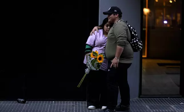 Fans of former One Direction singer Liam Payne stand outside the hotel where he was found dead after falling from a balcony in Buenos Aires, Argentina, Thursday, Oct. 17, 2024. (AP Photo/Natacha Pisarenko)