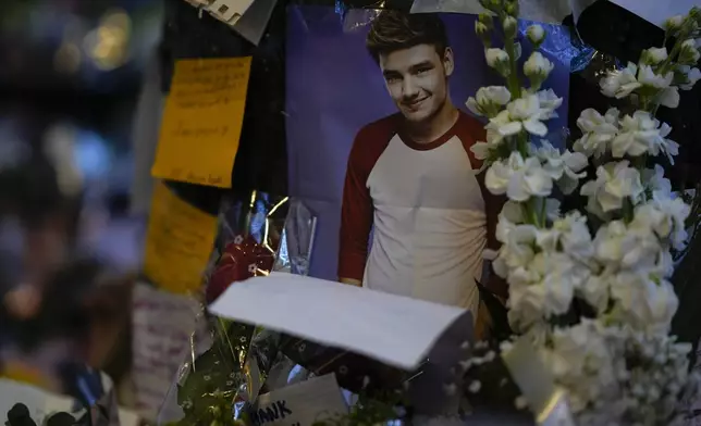 A picture of former One Direction singer Liam Payne adorns a memorial outside the hotel where he was found dead after falling from a balcony in Buenos Aires, Argentina, Thursday, Oct. 17, 2024. (AP Photo/Natacha Pisarenko)