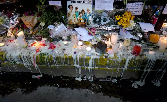 Candles and flowers adorn a memorial for former One Direction singer Liam Payne outside the hotel where he was found dead after falling from a balcony in Buenos Aires, Argentina, Thursday, Oct. 17, 2024. (AP Photo/Natacha Pisarenko)