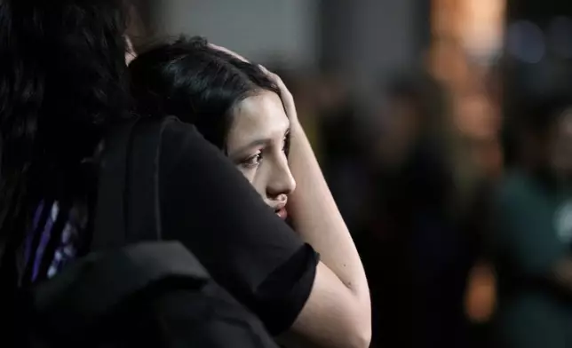 People embrace outside the hotel where former One Direction singer Liam Payne was found dead after he fell from a balcony in Buenos Aires, Argentina, Wednesday, Oct. 16, 2024. (AP Photo/Natacha Pisarenko)