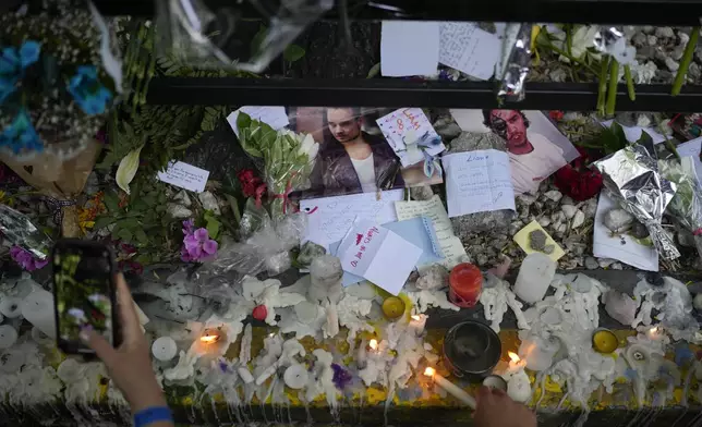 Fans of former One Direction singer Liam create a memorial outside the hotel where he was found dead after falling from a balcony in Buenos Aires, Argentina, Thursday, Oct. 17, 2024. (AP Photo/Natacha Pisarenko)