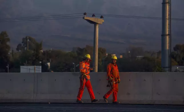 State workers head to work in La Rioja, Argentina, Friday, Sept. 13, 2024. In response to slashed federal budgets to provinces, La Rioja is printing a new emergency tender called "chachos" to pay state workers and spur the economy. (AP Photo/Natalia Diaz)