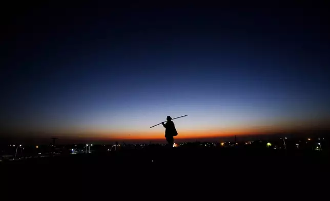 A monument to strongman Ángel Vicente “Chacho” Peñaloza, famed for defending La Rioja and other provinces in a historic 19th-century battle against national authorities, is silhouetted in La Rioja, Argentina, at dawn Friday, Sept. 13, 2024. In response to slashed federal budgets to provinces, La Rioja is printing a new emergency tender called "chachos" to pay state workers and spur the economy. (AP Photo/Natalia Diaz)