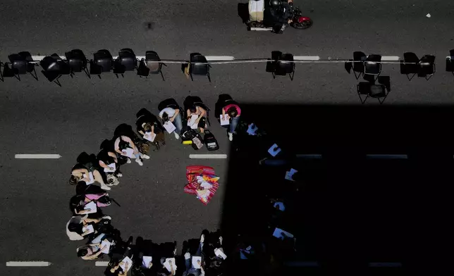 Students hold class in the middle of a street outside the Faculty of Psychology to protest President Javier Milei's veto of higher funding for public universities, in Buenos Aires, Argentina, Wednesday, Oct. 16, 2024. (AP Photo/Natacha Pisarenko)