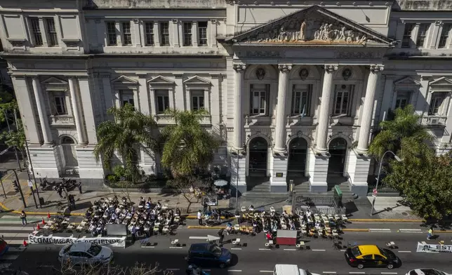 Economics students hold class outside in front of the University of Buenos Aires to protest President Javier Milei's veto of higher funding for public universities in Buenos Aires, Argentina, Wednesday, Oct. 16, 2024. (AP Photo/Victor R. Caivano)