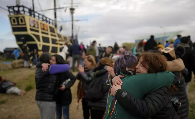 People embrace during an annular solar eclipse in Puerto San Julian, Argentina, Wednesday, Oct. 2, 2024. (AP Photo/Natacha Pisarenko)