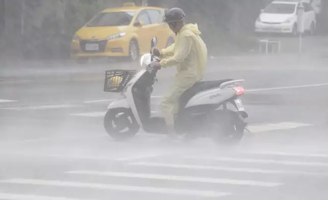 A man struggles in the heavy wind and rain generated by Typhoon Krathon in Kaohsiung, southern Taiwan, Thursday, Oct. 3, 2024. (AP Photo/Chiang Ying-ying)