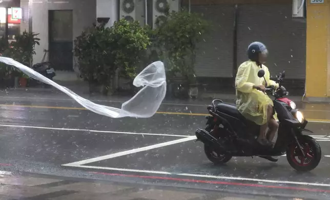 A man rides in the wind and rain generated by Typhoon Krathon in Kaohsiung, southern Taiwan, Thursday, Oct. 3, 2024. (AP Photo/Chiang Ying-ying)