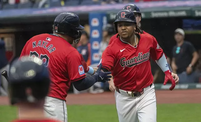 Cleveland Guardians' Josh Naylor, left, greets Jose Ramirez, right, after Ramirez hit a two-run home run off Houston Astros starting pitcher Justin Verlander during the first inning of a baseball game in Cleveland, Saturday, Sept. 28, 2024. (AP Photo/Phil Long)