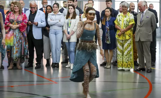 Britain's King Charles III, right, watches a performance by the Brogla Dance Academy group during a visit to the National Centre of Indigenous Excellence on Tuesday Oct. 22, 2024 in Sydney, Australia. (Lisa Maree Williams/Pool Photo via AP)