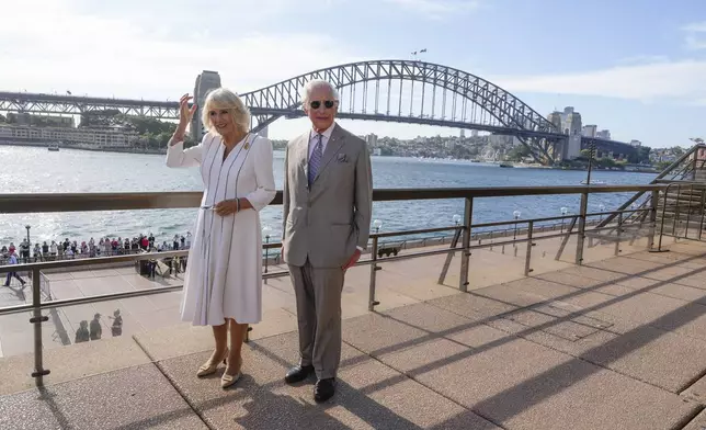 Britain's King Charles III, right, and Queen Camilla stand in front of the Sydney Harbour Bridge during their visit in Sydney, Australia, Tuesday, Oct. 22, 2024. (AP Photo/Mark Baker, Pool)