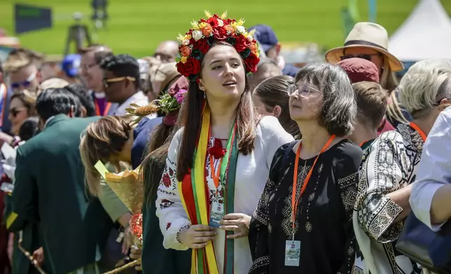 Members of the public wait for Britain's King Charles III and Queen Camilla to arrive to attend the Premier's Community BBQ on Tuesday Oct. 22, 2024 in Sydney, Australia. (Brook Mitchell/Pool Photo via AP)