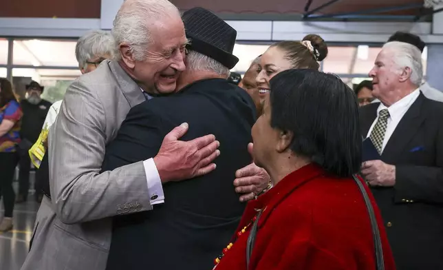 Britain's King Charles III receives a hug during a visit to the National Centre of Indigenous Excellence on Tuesday Oct. 22, 2024 in Sydney, Australia. (Lisa Maree Williams/Pool Photo via AP)