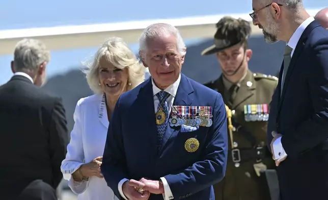 Britain's King Charles III, center, and Queen Camilla arrive at Defense Establishment Fairbairn in Canberra, Australia, Monday, Oct. 21, 2024. (Saeed Khan/Pool Photo via AP)