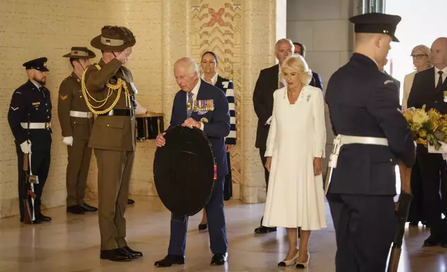 Britain's King Charles III, center left, and Queen Camilla, center right, arrive to lay a wreath at the Australian War Memorial in Canberra, Australia, Monday, Oct. 21, 2024. (Brook Mitchell/Pool Photo via AP)