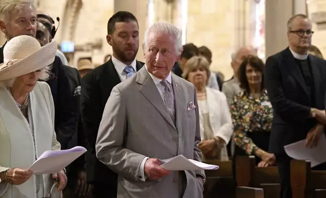 King Charles III, center, and Queen Camilla, left, stand during a visit to St Thomas' Anglican Church in Sydney, Sunday, Oct. 20, 2024. (Dean Lewins/Pool Photo via AP)