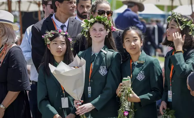 Members of the public wait for Britain's King Charles III and Queen Camilla to arrive to attend the Premier's Community BBQ on Tuesday Oct. 22, 2024 in Sydney, Australia. (Brook Mitchell/Pool Photo via AP)