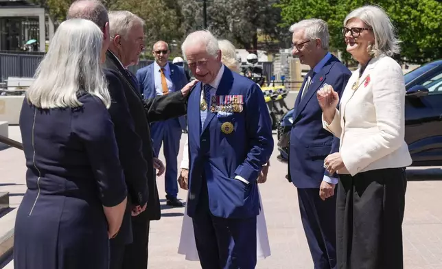 Kim Beazley, third left, chair of Australian War Memorial Council, meets Britain's King Charles III, center, on the king's arrival with Queen Camilla, partially seen at rear center, in Canberra, Australia, Monday, Oct. 21, 2024.