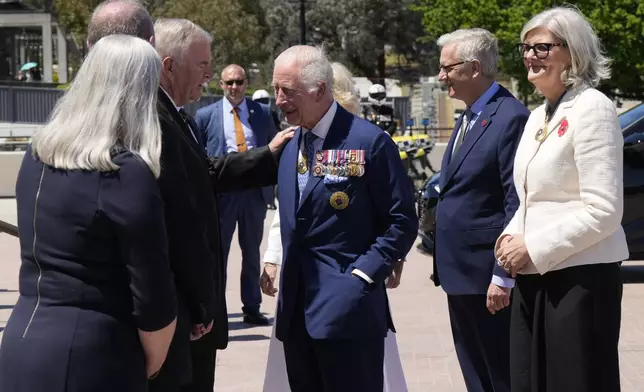 Kim Beazley, third left, chair of Australian War Memorial Council, meets Britain's King Charles III, center, on the king's arrival with Queen Camilla, partially seen at rear center, in Canberra, Australia, Monday, Oct. 21, 2024.