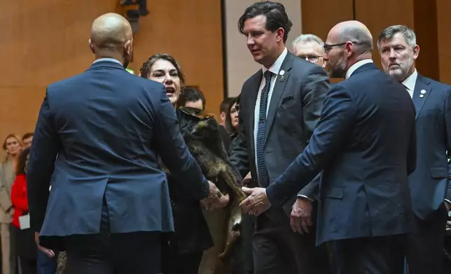 Australian Senator Lidia Thorpe, centre, is ushered away as she disrupts proceedings while Britain's King Charles and Queen Camilla attend a Parliamentary reception hosted by Australian Prime Minister Anthony Albanese and partner Jodie Haydon at Parliament House in Canberra, Australia, Monday, Oct. 21, 2024. (Lukas Coch/Pool Photo via AP)