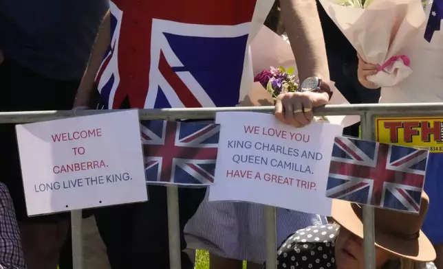 Royal supporters with greeting plate card to at Australian War Memorial to welcome Britain's King Charles and Queen Camilla visit in Canberra, Australia, Monday, Oct. 21, 2024. (AP Photo/Mark Baker, Pool)