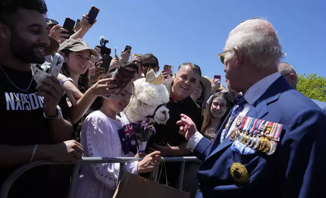 Britain's King Charles III, tight, chat with owner of alpaca before leave the Australian War Memorial in Canberra, Monday, Oct. 21, 2024. (AP Photo/Mark Baker, Pool)