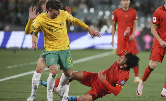 China's Hu Hetao reacts after a collision with Australia's Jordan Bos, left, during the World Cup 2026 Group C qualifying soccer match between Australia and China at Adelaide Oval, Adelaide, Australia, Thursday Oct. 10, 2024. (AP Photo/James Elsby)