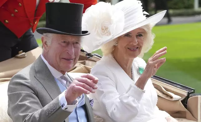 FILE - Britain's King Charles III and Queen Camilla wave to the crowds as they arrive by carriage in the parade ring on the third day of the Royal Ascot, horse race meeting, traditional known as Ladies Day, at Ascot, England, on June 20, 2024. (AP Photo/Kin Cheung, File)