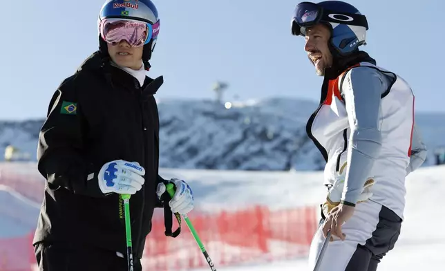 Brazil's Lucas Pinheiro Braathen, left, and Netherland's Marcel Hirscher share a word ahead of an alpine ski, men's World Cup giant slalom, in Soelden, Austria, Sunday, Oct. 27, 2024. (AP Photo/Alessandro Trovati)