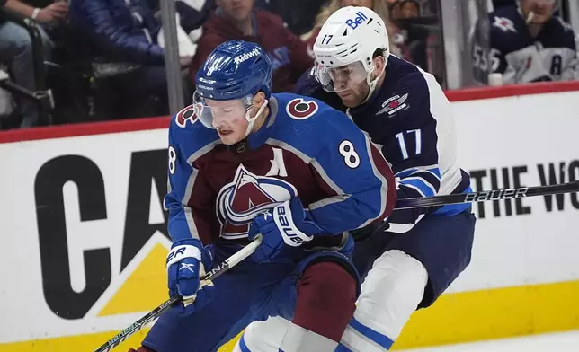 FILE - Colorado Avalanche defenseman Cale Makar, left, collects the puck with Winnipeg Jets center Adam Lowry, right, in pursuit in the second period of Game 4 of an NHL Stanley Cup first-round playoff series Sunday, April 28, 2024, in Denver. (AP Photo/David Zalubowski)