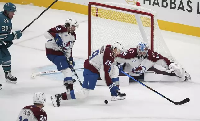 Colorado Avalanche players Samuel Girard (49), center left, Nathan MacKinnon (29), center right, and Justus Annunen (60), far right, defend a shot as San Jose Sharks left wing Fabian Zetterlund (20) looks to score during the third period of an NHL hockey game in San Jose, Calif., Sunday, Oct. 20, 2024. (AP Photo/Minh Connors)