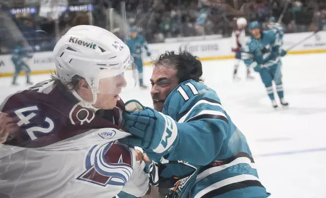 Colorado Avalanche defenseman Josh Manson (42) and San Jose Sharks center Luke Kunin (11) fist fight during the first period of an NHL hockey game in San Jose, Calif., Sunday, Oct. 20, 2024.