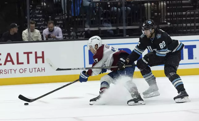 Colorado Avalanche forward Parker Kelly (17) fights for the puck against Utah Hockey Club forward Kevin Stenlund (82) during the second period of an NHL hockey game Thursday, Oct. 24, 2024, in Salt Lake City. (AP Photo/Melissa Majchrzak)