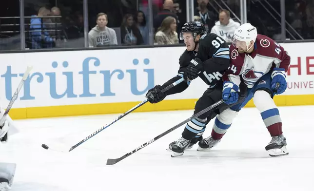 Utah Hockey Club forward Josh Doan (91) shoots the puck against Colorado Avalanche defensemen Calvin de Haan (44) during the second period of an NHL hockey game Thursday, Oct. 24, 2024, in Salt Lake City. (AP Photo/Melissa Majchrzak)