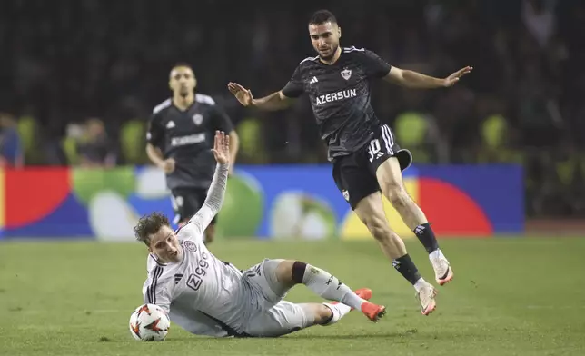 Qarabag's Abbas Huseynov, right, challenges for the ball with Ajax's Mika Godts during the Europa League soccer match between Qarabag and Ajax at the Tofiq Bahramov Republican stadium in Baku, Azerbaijan, Thursday, Oct. 24, 2024. (AP Photo)