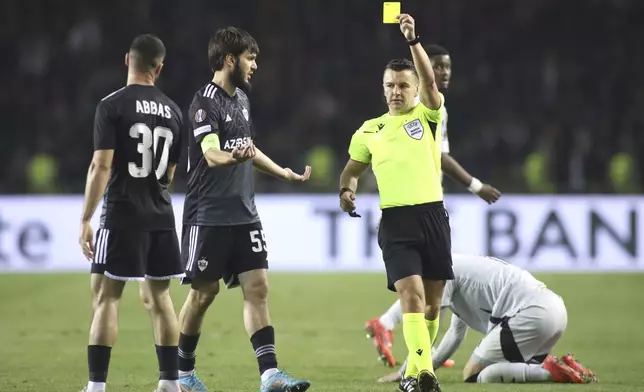 Referee Nick Walsh shows a yellow card to Qarabag's Badavi Guseynov, centre left, during the Europa League soccer match between Qarabag and Ajax at the Tofiq Bahramov Republican stadium in Baku, Azerbaijan, Thursday, Oct. 24, 2024. (AP Photo)