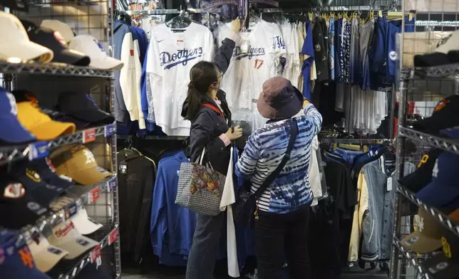 Customers shop around for goods related to Shohei Ohtani of the Los Angeles Dodgers at a sporting goods store, "SELECTION," in Shinjuku district Wednesday, Oct. 23, 2024 in Tokyo. (AP Photo/Eugene Hoshiko)