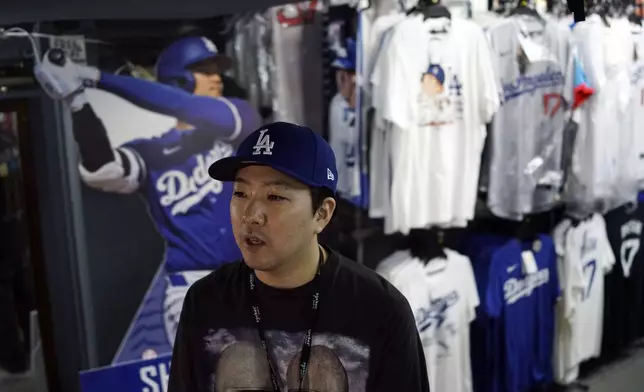 Store manager Takeru Watanabe speaks in front of goods related to Shohei Ohtani of the Los Angeles Dodgers at a sporting goods store, "SELECTION," in Shinjuku district Wednesday, Oct. 23, 2024 in Tokyo. (AP Photo/Eugene Hoshiko)