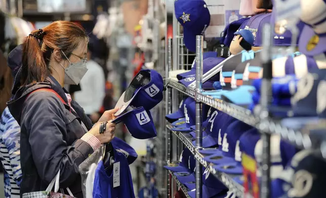 A customer shops around for goods related to Shohei Ohtani of the Los Angeles Dodgers at a sporting goods store, "SELECTION," in Shinjuku district Wednesday, Oct. 23, 2024 in Tokyo. (AP Photo/Eugene Hoshiko)