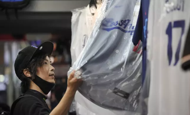 A customer Jiro Nishi, shops around for goods related to Shohei Ohtani of the Los Angeles Dodgers at a sporting goods store, "SELECTION," in Shinjuku district Wednesday, Oct. 23, 2024 in Tokyo. (AP Photo/Eugene Hoshiko)