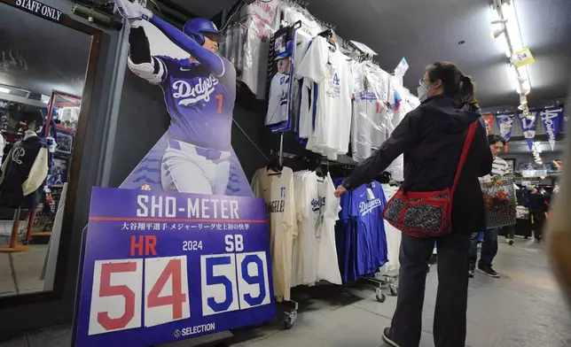 Customers shop around for goods related to Shohei Ohtani of the Los Angeles Dodgers at a sporting goods store, "SELECTION," in Shinjuku district Wednesday, Oct. 23, 2024 in Tokyo. (AP Photo/Eugene Hoshiko)