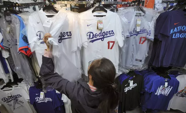 A customer shops around for goods related to Shohei Ohtani of the Los Angeles Dodgers at a sporting goods store, "SELECTION," in Shinjuku district Wednesday, Oct. 23, 2024 in Tokyo. (AP Photo/Eugene Hoshiko)