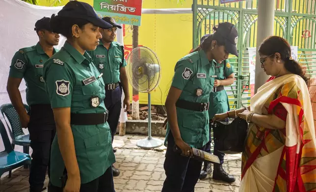 A police woman checks a bag of a woman devotee at the Dhakeshwari National Temple during the Durgapuja festival in Dhaka, Bangladesh, on Oct. 10, 2024. (AP Photo/Rajib Dhar)