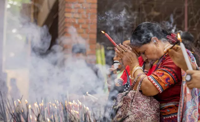 A woman offers prayer at the Dhakeshwari National Temple during the Durgapuja festival in Dhaka, Bangladesh, on Oct. 10, 2024. (AP Photo/Rajib Dhar)