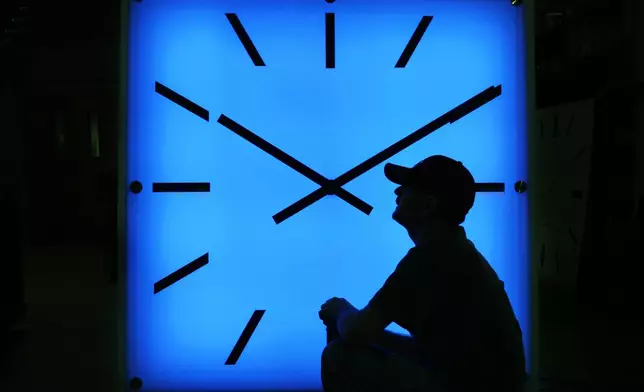 FILE - In this Oct. 30, 2008, file photo, an Electric Time Company employee adjusts the color on a clock at the plant in Medfield, Mass., days before the switch to standard time. (AP Photo/Elise Amendola, File)