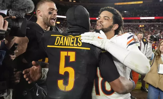 Washington Commanders quarterback Jayden Daniels (5) is congratulated by Chicago Bears quarterback Caleb Williams (18) after the Commanders won 18-15 in an NFL football game Sunday, Oct. 27, 2024, in Landover, Md. (AP Photo/Stephanie Scarbrough)