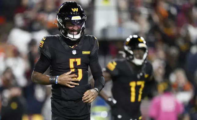 Washington Commanders quarterback Jayden Daniels (5) winces in pain after a play in the second half of an NFL football game against the Chicago Bears Sunday, Oct. 27, 2024, in Landover, Md. (AP Photo/Nick Wass)