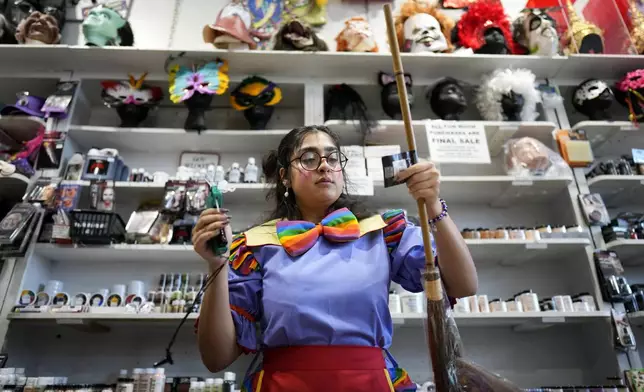 Hamida Mokhtar prices merchandise at The Theatrical Shop, Tuesday, Oct. 29, 2024, in West Des Moines, Iowa. (AP Photo/Charlie Neibergall)